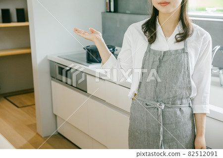 A woman standing in the kitchen, a woman giving a sign in the kitchen A woman standing in the kitchen, a woman giving a sign in the kitchen 82512091