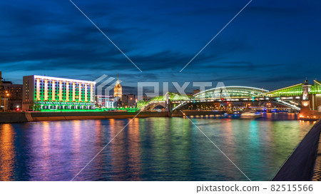 View of the colorful Bogdan Khmelnitsky bridge illuminated at night reflecting in the Moskova river. Moscow Kiyevsky railway station at night. Moscow, Russia View of the colorful Bogdan Khmelnitsky bridge illuminated at night reflecting in the Moskova river. Moscow Kiyevsky railway station at night. Moscow, Russia 82515566