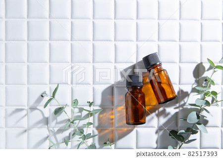 Two bottles of aroma oil and eucalyptus leaves. There is copy space. 82517393