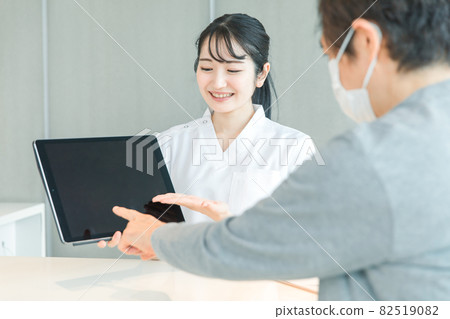 接受平板電腦的女性和穿著白大褂的患者 82519082