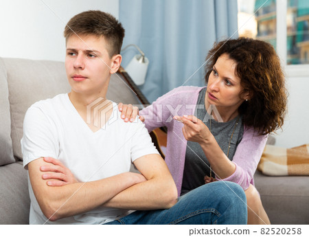 Worried mother talking to son 82520258