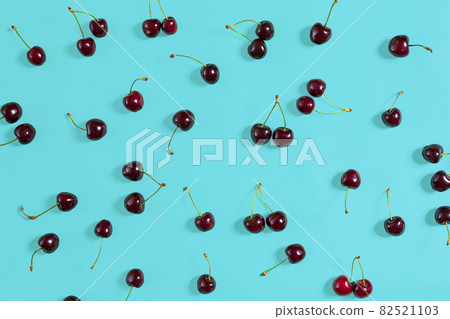 Fresh juicy cherries on mint background, top view Fresh juicy cherries on mint background, top view 82521103