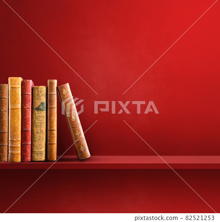 Row of old books on red shelf. Square background Row of old books on red shelf. Square background 82521253