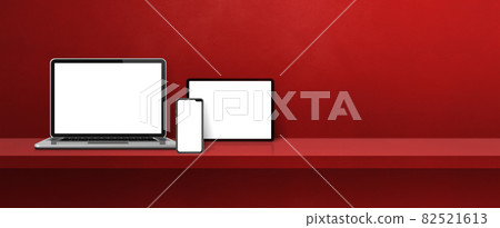 Laptop, mobile phone and digital tablet pc on red wall shelf. Banner background 82521613