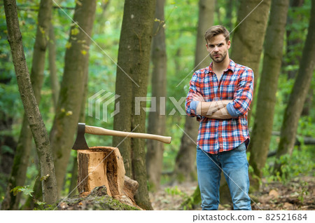Good looking man posing with axe, nature 82521684