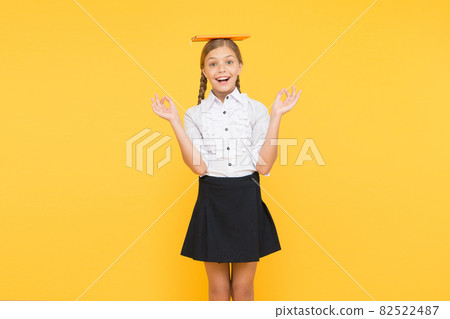 School girl studying textbook. Kid school uniform hold  82522487