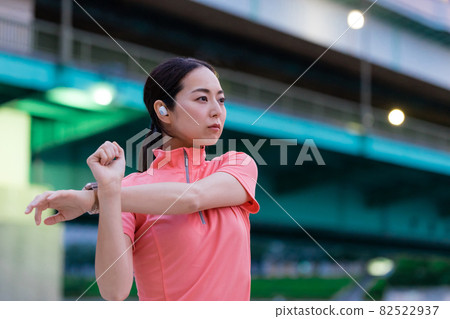 A woman in sportswear operating a smartwatch 82522937