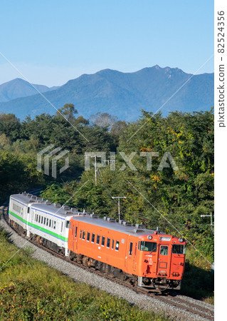 JR Hokkaido Kiha 40-1700 3-car train Vertical photo Going on a large curve while looking at the Hidaka Mountains 82524356
