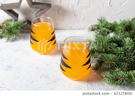 orange mandarin cocktail in glass with black stripes. Christmas holiday welcome drink. Concept for children new year 82525609