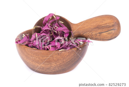 Dried Echinacea flowers in wooden bowl and spoon, isolated on white background. Petals of Echinacea purpurea. Medicinal herbs. 82529273