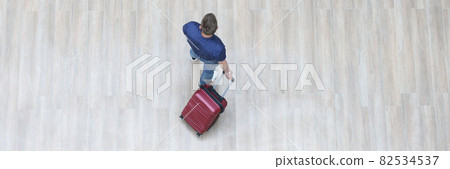 Male tourist walking with suitcase top view Male tourist walking with suitcase top view 82534537