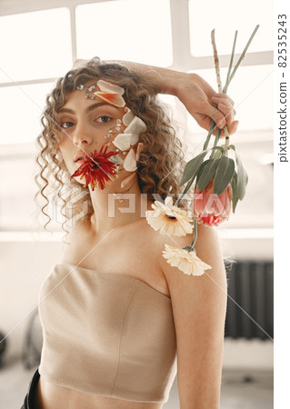Portrait of a beautiful young woman with flowers 82535243