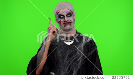 Inspired Halloween crazy zombie man pointing finger up with open mouth, showing Eureka gesture 82535761
