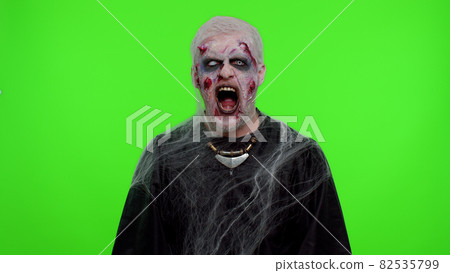 Sinister man in costume of Halloween crazy zombie with bloody wounded scars face screaming, shouting Sinister man in costume of Halloween crazy zombie with bloody wounded scars face screaming, shouting 82535799