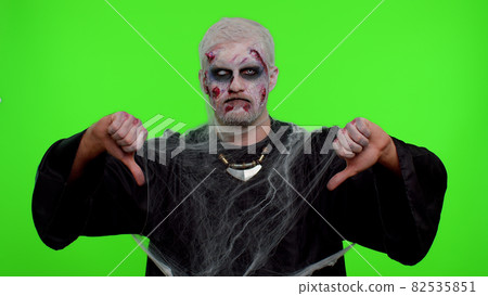 Scary man Halloween zombie showing thumbs down sign gesture, disapproval, dissatisfied, dislike 82535851