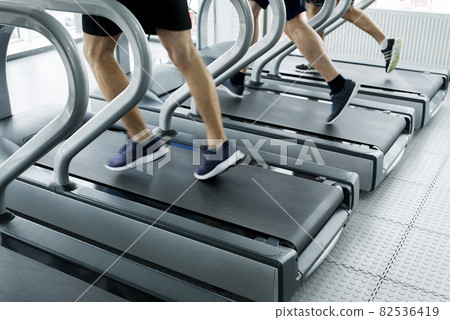 gym shot - people running on machines, treadmill with motion blur gym shot - people running on machines, treadmill with motion blur 82536419