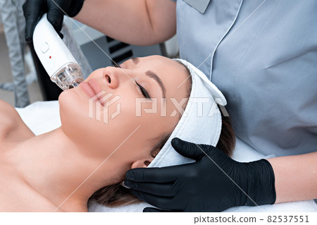 Young woman receiving laser treatment in cosmetology clinic 82537551