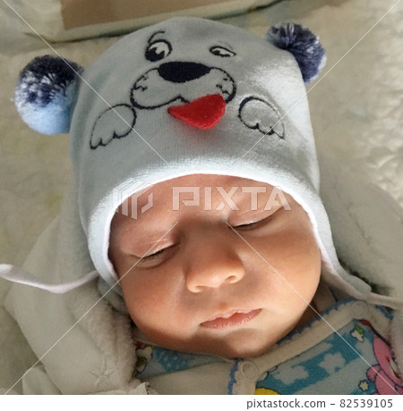 Beautiful sleeping baby boy with child hat posing photographer for color photo 82539105