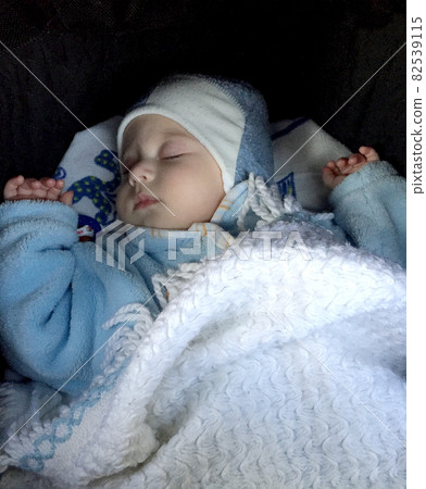 Beautiful sleeping baby boy with child hat posing photographer for color photo 82539115