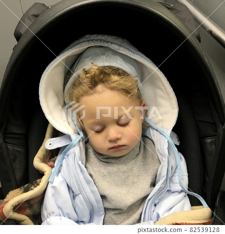 Beautiful sleeping baby boy with child hat posing photographer for color photo 82539128