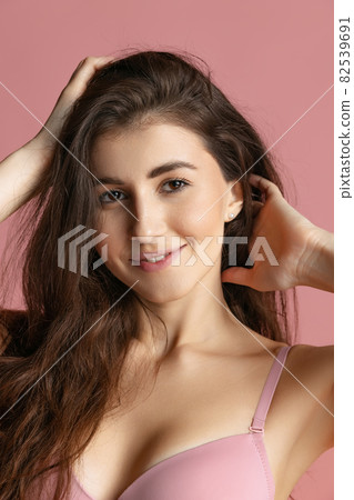 Close-up portrait of young beautiful girl without makeup isolated over pink studio background. Natural beauty concept. Close-up portrait of young beautiful girl without makeup isolated over pink studio background. Natural beauty concept. 82539691
