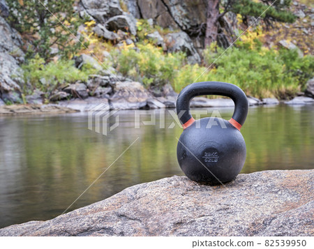 iron kettlebell on a shore of mountain river 82539950