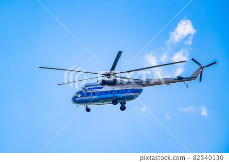 Helicopter flies in the blue sky 82540130