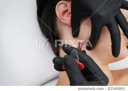 Beautiful woman gets an injection in her face Beautiful woman gets an injection in her face 82540861