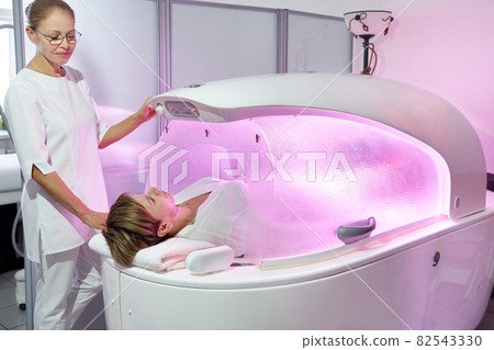 Modern spa treatment capsule in cosmetology clinic, cosmetologist operating equipment Modern spa treatment capsule in cosmetology clinic, cosmetologist operating equipment 82543330