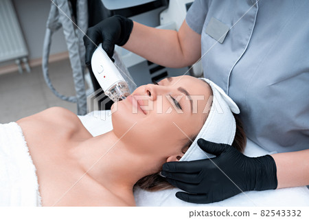 Young woman receiving laser treatment in cosmetology clinic 82543332