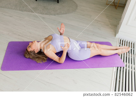 Health concept. Young beautiful woman does yoga exercise in the modern room 82546062