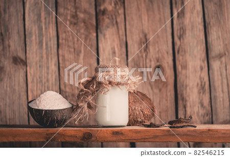 Coconut shavings and coconut oil on black background. Coconut with coconut flakes 82546215
