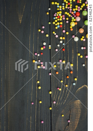 Colorful Foam ball on a black wooden background Colorful Foam ball on a black wooden background 82546245
