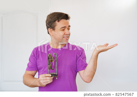 repairman of washing machine holds old tubular electric heater  82547567