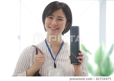 一個女人從包裡拿出一個水瓶 一個女人從包裡拿出一個水瓶 82556975