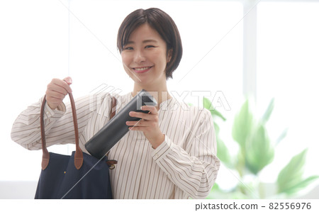 A woman taking out a water bottle from a bag 82556976