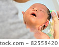 A baby bathing comfortably in the hands of a mother 82558420