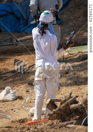 A female craftsman who conducts on-site command with a computer in one hand A female craftsman who conducts on-site command with a computer in one hand 82560173