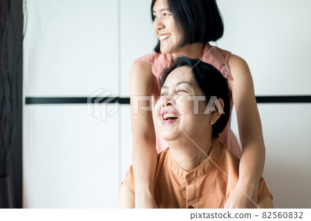 Asian mature woman laughing with daughter take care and support at home,Happy elderly middle aged mom,Senior insurance concept Asian mature woman laughing with daughter take care and support at home,Happy elderly middle aged mom,Senior insurance concept 82560832