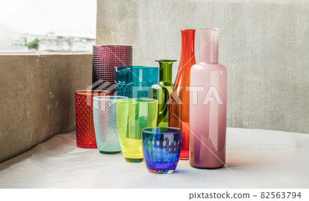 Many Different glass jar and glass cups and surface reflections on pink table cloth. Many Different glass jar and glass cups and surface reflections on pink table cloth. 82563794