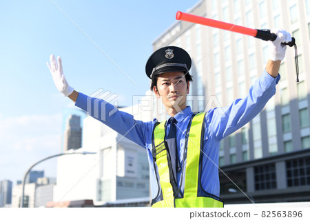 A guard man man who guides traffic with a guide rod 82563896