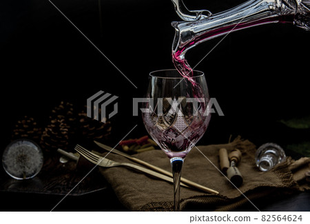 Flat lay composition with Pouring red wine from pitcher into the wineglass : traditional winemaking and wine tasting concept. 82564624