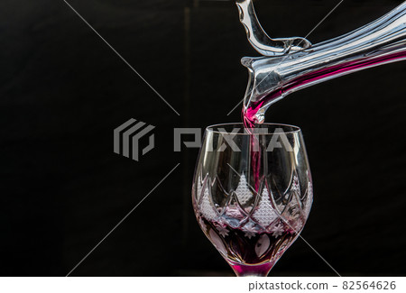 Flat lay composition with Pouring red wine from pitcher into the wineglass : traditional winemaking and wine tasting concept. 82564626