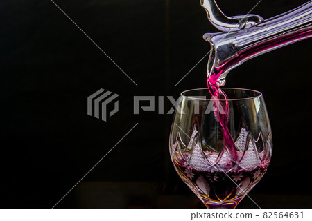 Flat lay composition with Pouring red wine from pitcher into the wineglass : traditional winemaking and wine tasting concept. 82564631