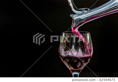 Flat lay composition with Pouring red wine from pitcher into the wineglass : traditional winemaking and wine tasting concept. 82564673