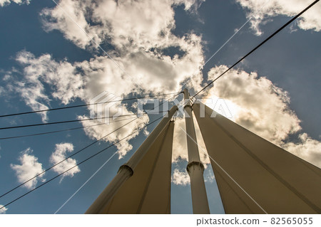 Connection points of tension membrane roof. Turnbuckle wire rope tension for tension membrane roof on a blue sky background. Connection points of tension membrane roof. Turnbuckle wire rope tension for tension membrane roof on a blue sky background. 82565055