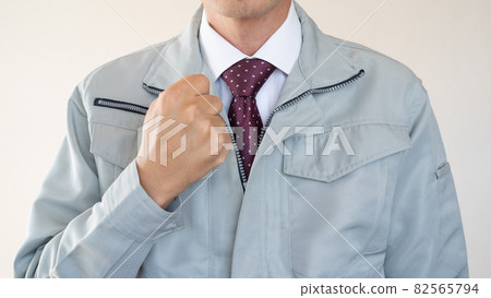 A man in work clothes and a tie. A man in work clothes and a tie. 82565794