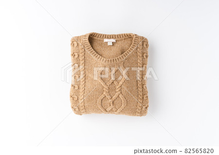 Beige folded sweater isolated on white background. Flat lay. Top view Beige folded sweater isolated on white background. Flat lay. Top view 82565820