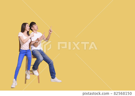 happy excited Asian couple pointing hands empty  82568150