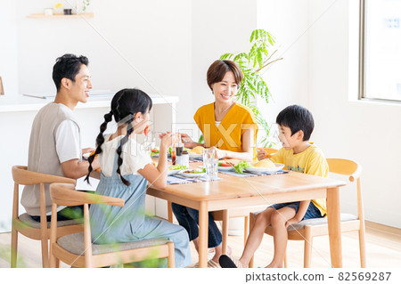 Family of four eating in the dining room 82569287